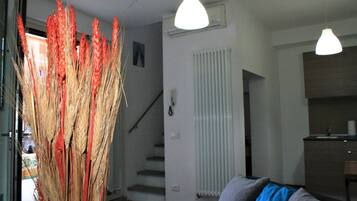 Un interno moderno con una scala, un termosifone e un angolo cottura.