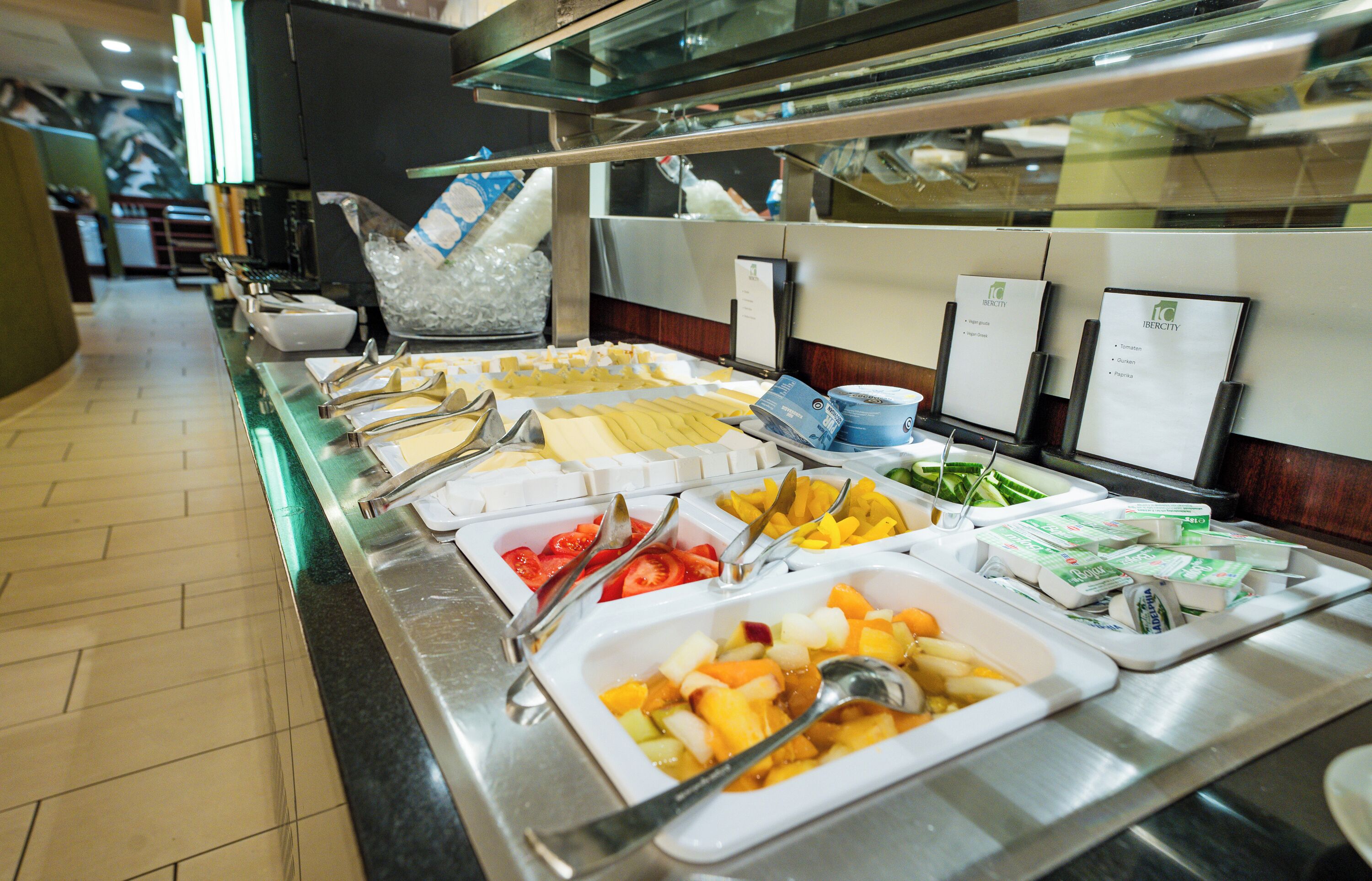 Een buffet met diverse etenswaren, zoals fruit, groenten en zuivelproducten.