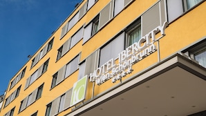 Een hotelgebouw met een gele gevel en veel ramen.