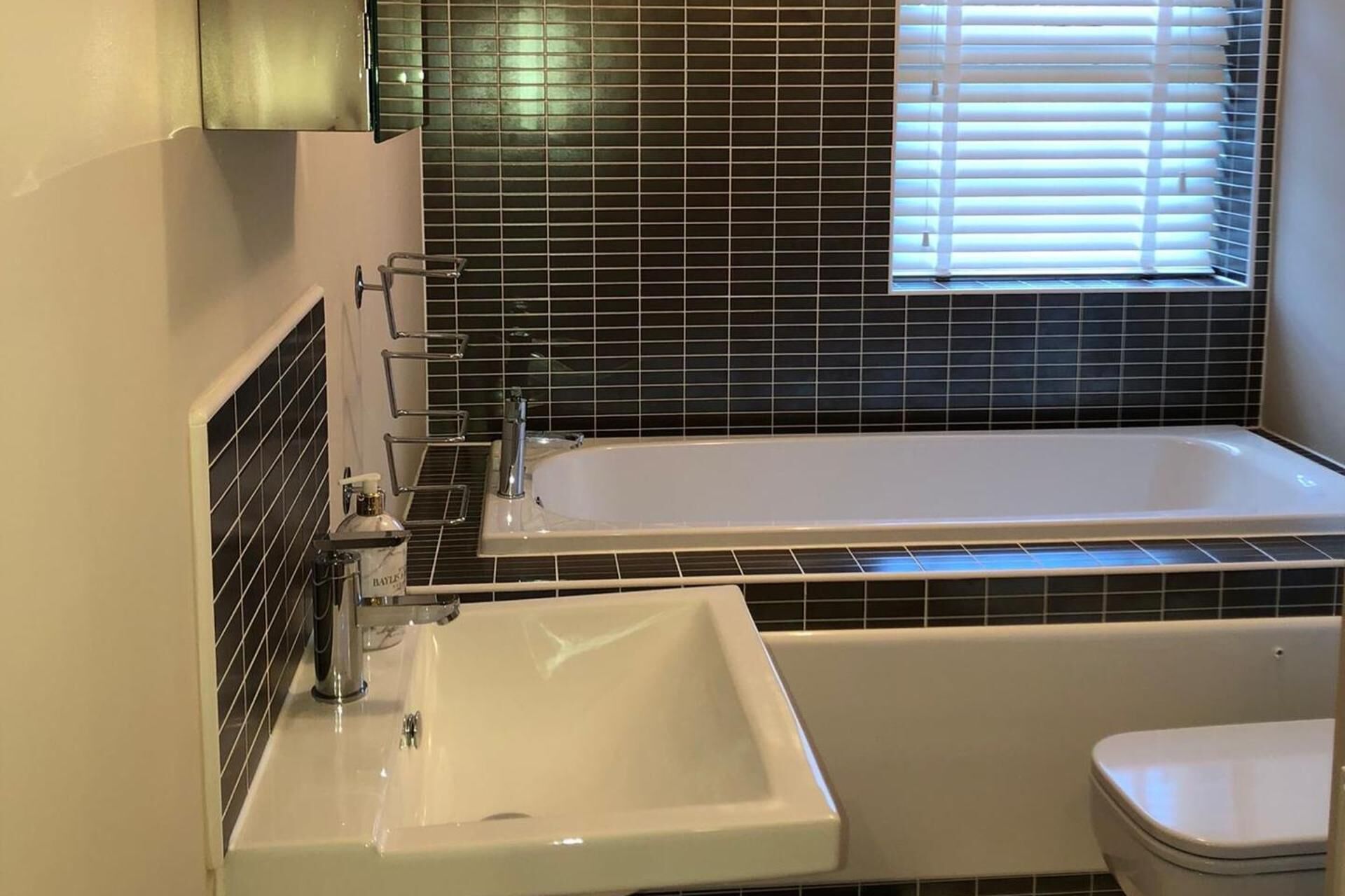 Een aparte badkuip en douche, een diep bad, handdoeken