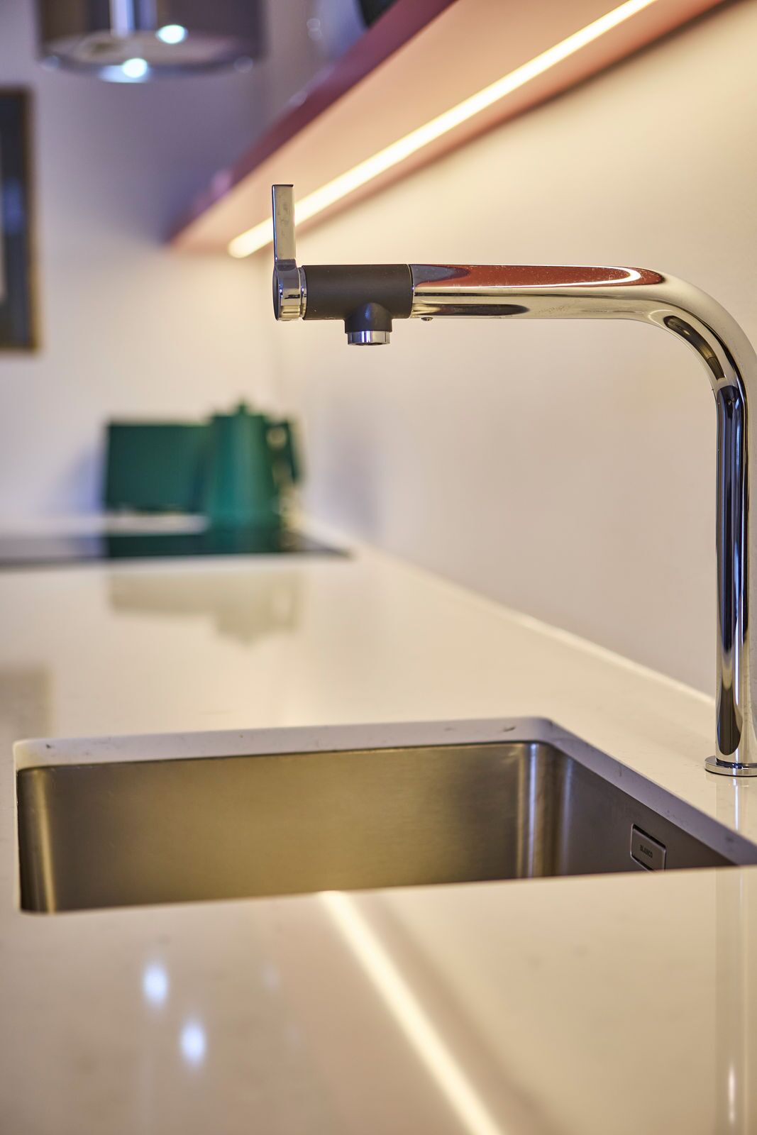 A modern kitchen with a stainless steel sink and a sleek faucet.