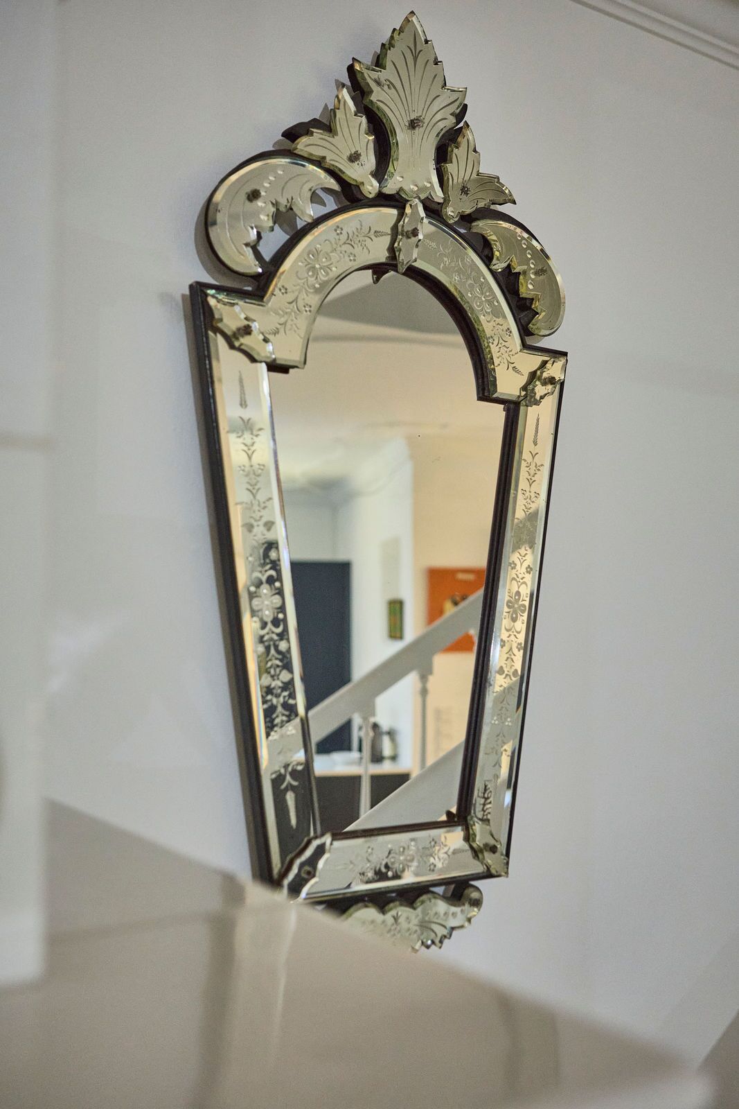 Un espejo rectangular con un marco dorado ornamentado que presenta diseños de hojas.