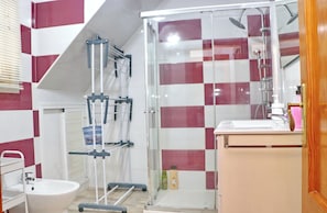 A bathroom with a glass shower enclosure, a white sink, and a mirror above the sink.
