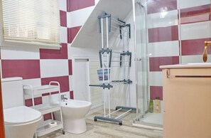 Un baño con inodoro, bidé y zona de ducha.