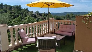 An outdoor patio with a yellow umbrella, a table, two chairs, and a sofa. - Holiday Home with Pool, Mountain View, Wi-Fi and Air Conditioning (Callas)
