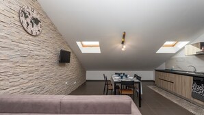 A modern loft with a dining area, kitchen, and a large window. - Apartment 'Sophia' with Mountain View, Shared Terrace and Air Conditioning (Fiumefreddo Sicilia)