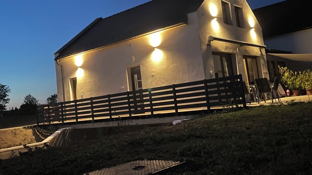 A two-story house with a sloped roof, a balcony with a railing, and a small garden area. - Vacation villa "Twin Garden" in Zánka, 5 minutes from Lake Balaton. Garden & Terrace. (Zánka)