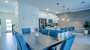 A modern kitchen with white cabinets, a stainless steel refrigerator, and a built-in microwave. - 4BR Storey Lake Townhome, Heated Pool (Kissimmee)