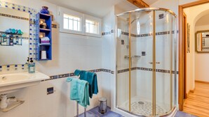 A bathroom with a glass-enclosed shower, a sink with a mirror, and a tiled backsplash. - Guest Rooms 'La Palmeraie' with Sea View, Wi-Fi and Air Conditioning (Portiragnes)