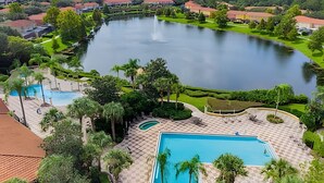 Un resort con múltiples piscinas, un lago extenso y jardines bien cuidados.