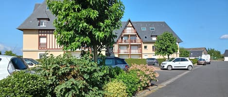 En bostadsbyggnad med en traditionell arkitektonisk stil, kännetecknad av ett sadeltak och en balkong på översta våningen.