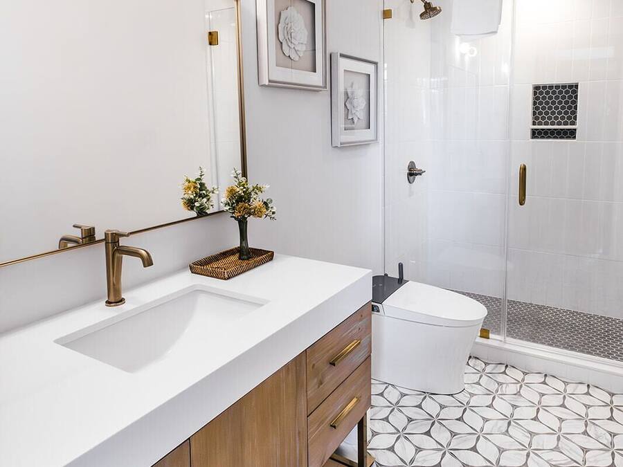 Une salle de bain moderne avec un grand miroir, deux lavabos, une douche et un carrelage décoratif.
