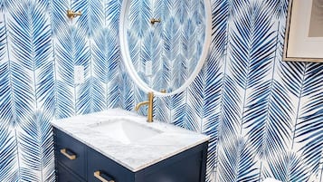 A bathroom with a vanity, a mirror, and a toilet.
