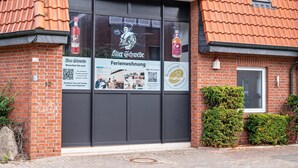 A brick building with a large window displaying advertisements for a distillery and a tour.