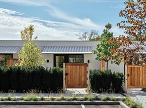 A modern house with a white exterior, two wooden doors, and a grey awning. - Belden House & Mews (Litchfield)