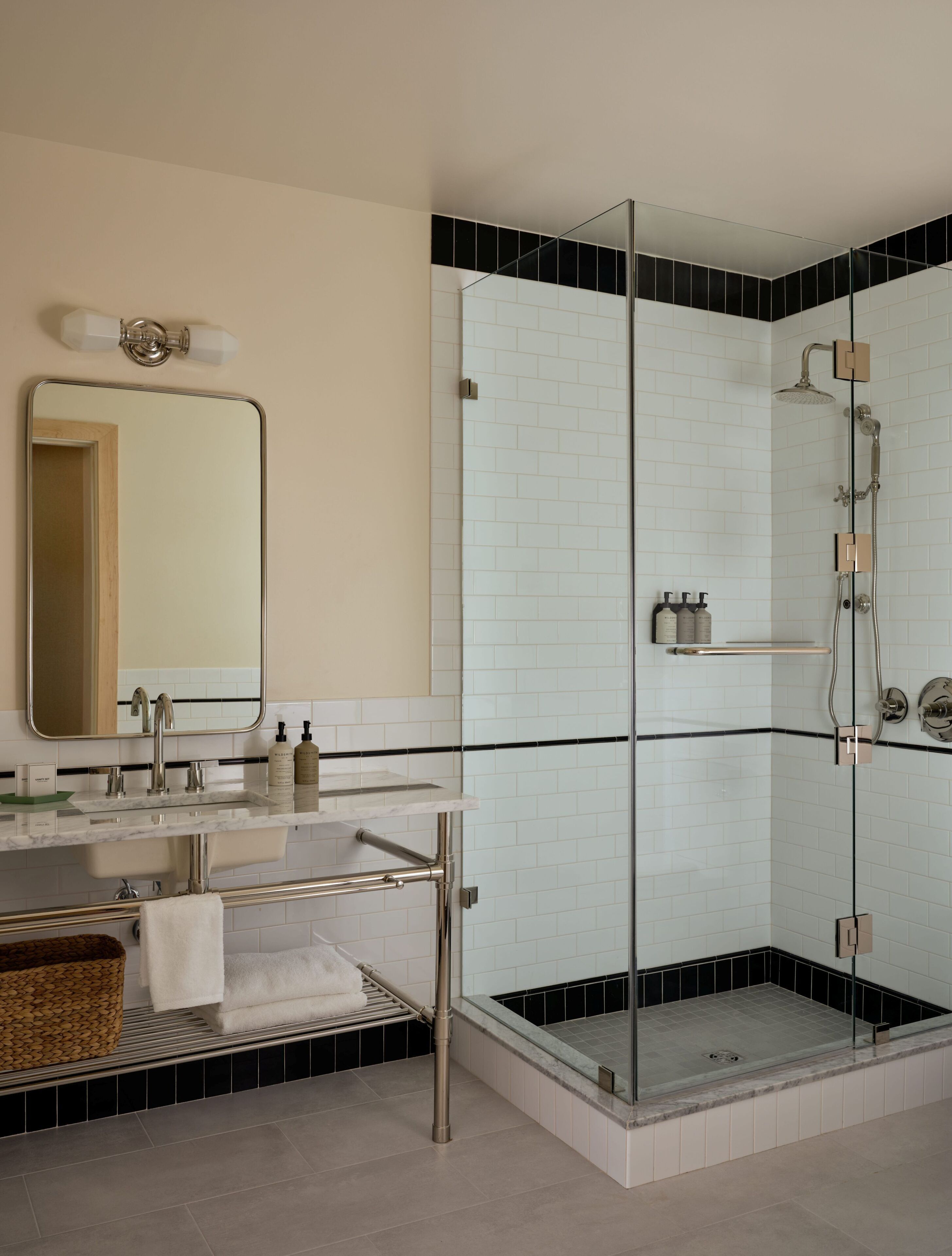 A modern bathroom with a glass-enclosed shower, a vanity with a mirror, and a sink.