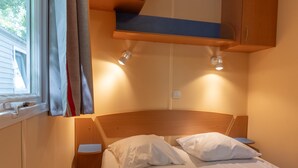 Una camera da letto con un letto, due comodini, una testiera e una finestra con tende.