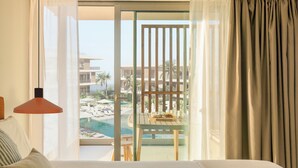 A hotel room with a balcony overlooking a pool and resort buildings. - KORA TIGOT (San Miguel de Abona)