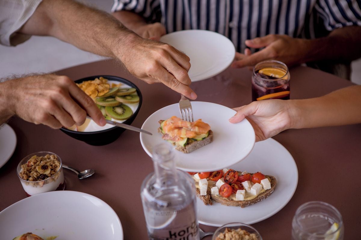 Une table à manger avec des assiettes remplies de nourriture, un verre et une bouteille.