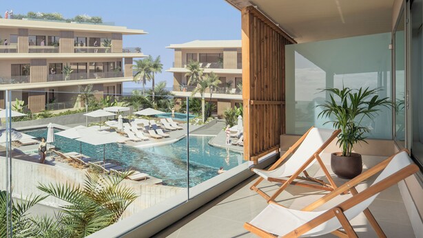 A balcony with a glass railing overlooking a swimming pool area with lounge chairs and umbrellas. - KORA TIGOT (San Miguel de Abona)