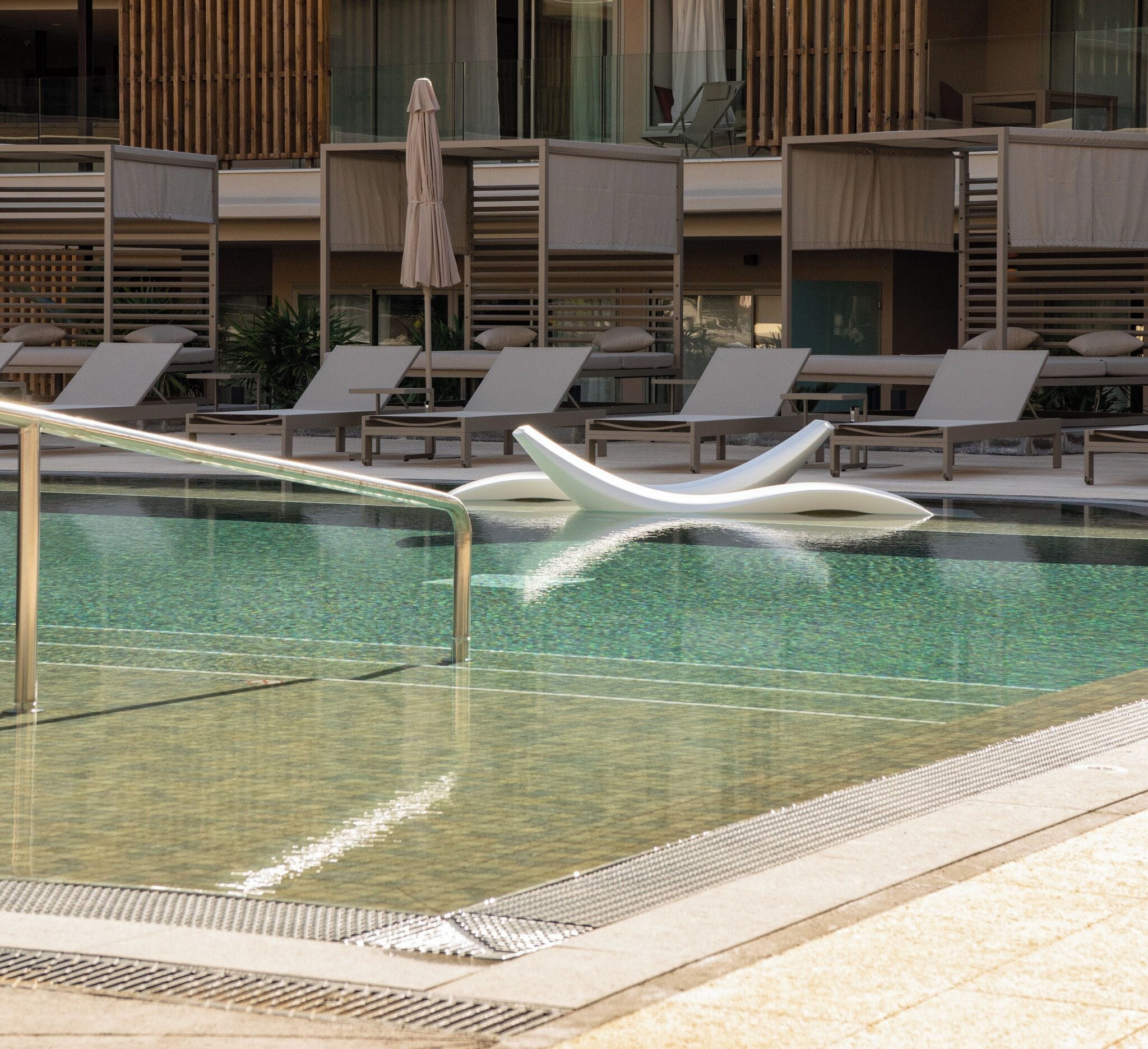 A modern pool area with lounge chairs and a poolside deck.