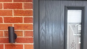 A dark wooden door with a frosted glass panel, a metal handle, and a keyhole. - Luxurious New House Near Manchester Airport (Wythenshawe)