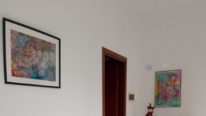 Un comedor con una mesa y sillas, un radiador y dos cuadros en las paredes.