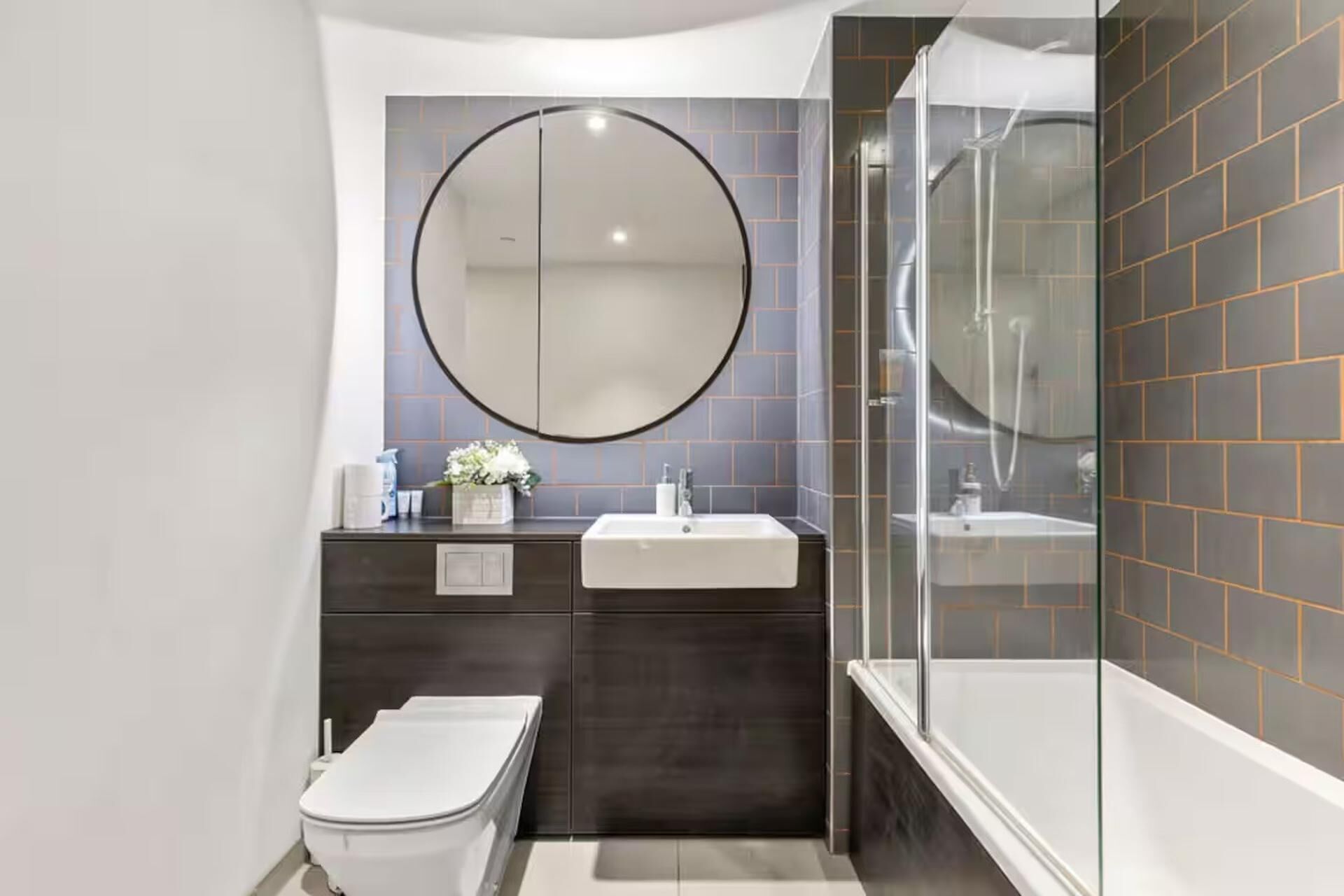 A modern bathroom with a toilet, sink, and shower area.
