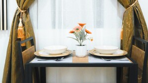 Comedor con una mesa para dos, con un florero de flores y una vela.