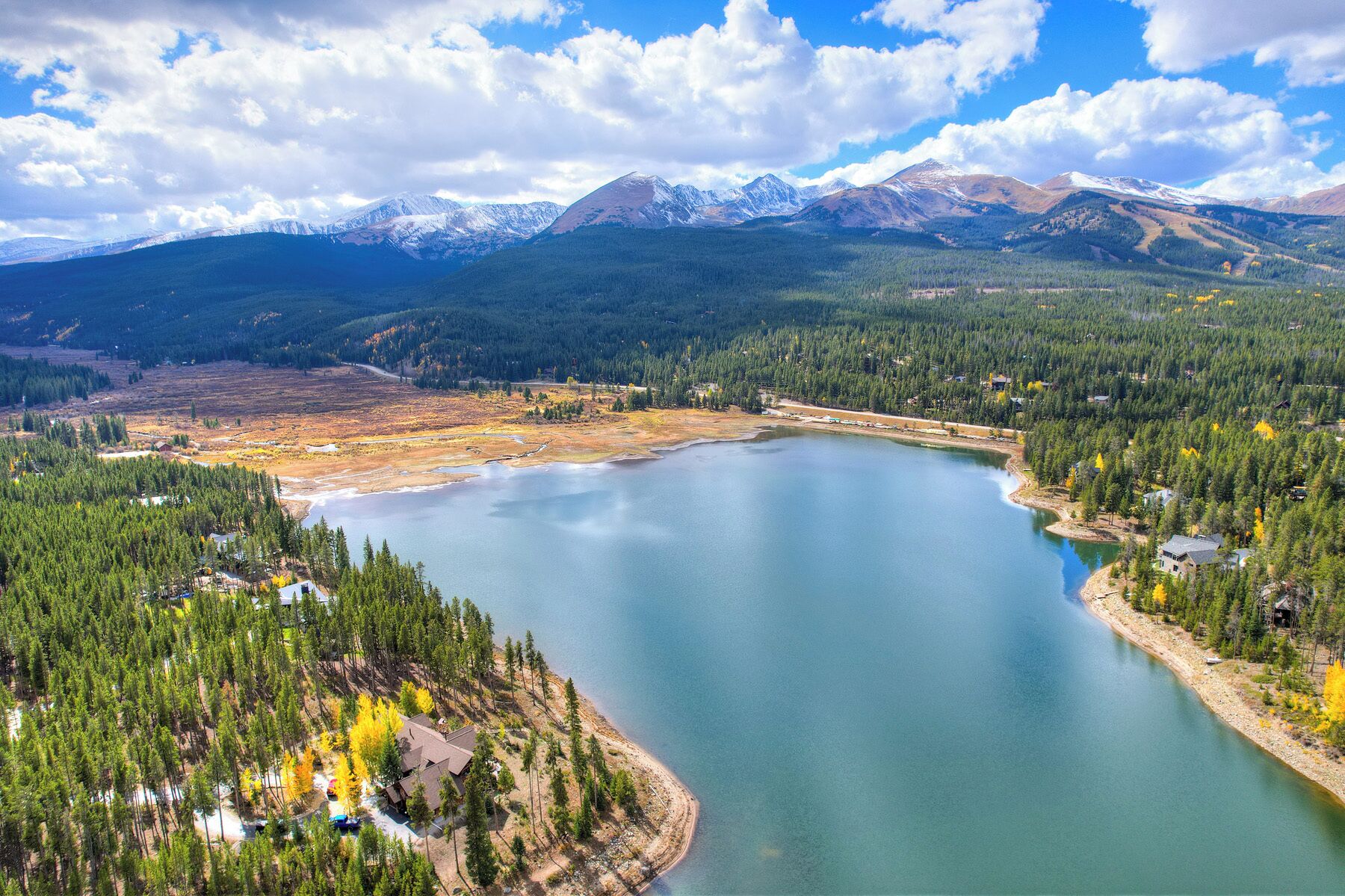 Un lac entouré de forêts denses et de montagnes.