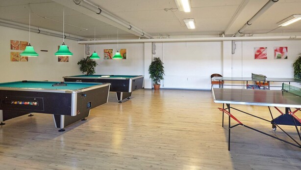 A recreational area with pool tables and a ping pong table, wooden flooring, and green pendant lights. - 6 Person Holiday Park Home in Glesborg (Glesborg)