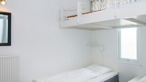 A bunk bed room with a window, a radiator, and a framed picture on the wall. - 6 Person Holiday Park Home in Glesborg (Glesborg)