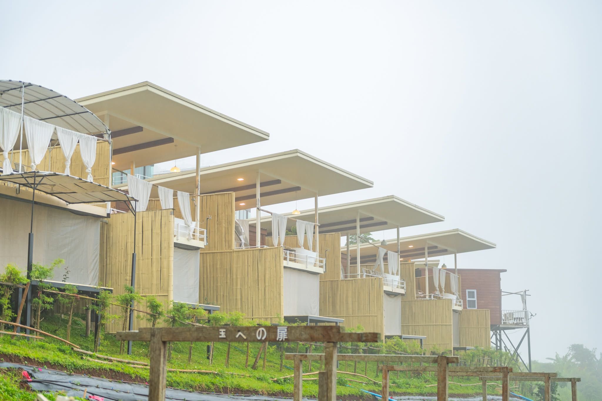 A series of wooden structures with multiple levels, some with covered areas and others with open sides.