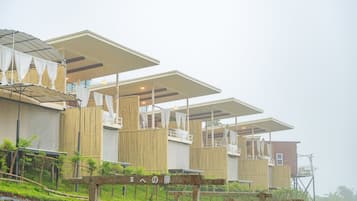 A series of wooden structures with multiple levels, some with covered areas and others with open sides.