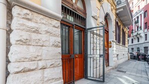 A building with a stone facade, a wooden door, and a metal gate.