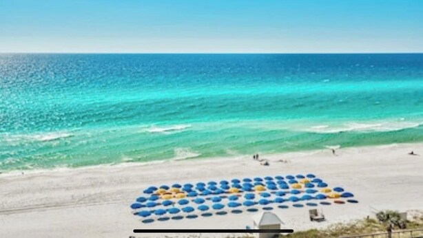 A beach with umbrellas arranged in a pattern, a clear blue sky, and the ocean. - 5 Bedroom | Sleeps 19 | Eagles Dune | Patio | Santa Rosa Beach (Santa Rosa Beach)