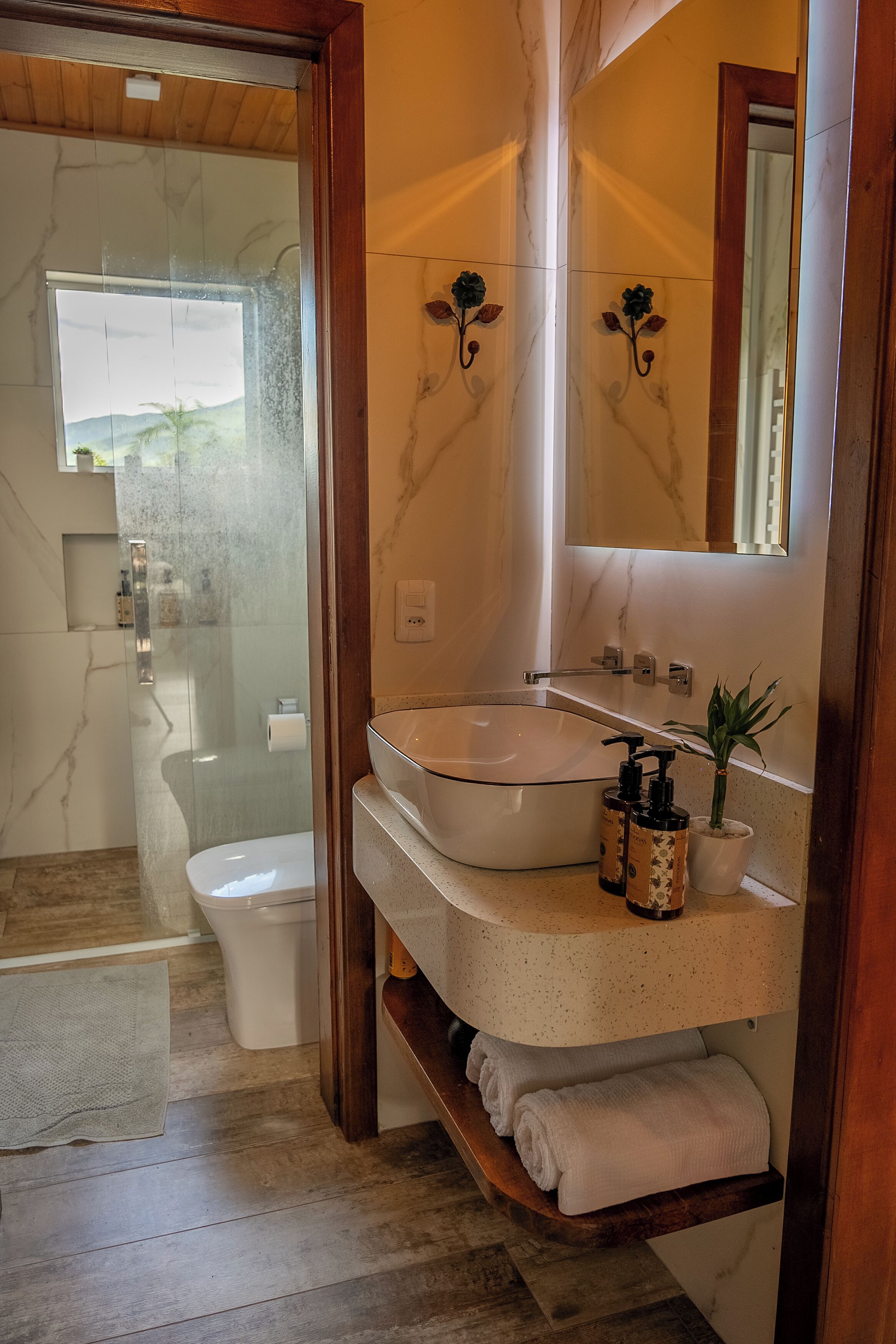 Un baño moderno con ducha envuelta en vidrio, inodoro blanco y bañera independiente.