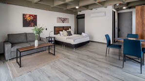 Un dormitorio moderno con cama, sofá, mesa de comedor y sillas.