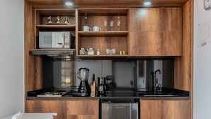 Una cocina moderna con armarios de madera, un refrigerador de acero inoxidable, una cafetera y un microondas.