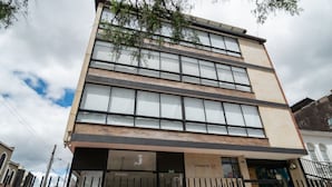 Un immeuble à plusieurs étages doté de grandes fenêtres et d’une enseigne indiquant « ATARDECER 57 ».