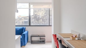 Une cuisine moderne avec un plan de travail en bois, une chaise rouge et un canapé bleu en arrière-plan.