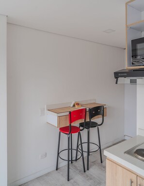 A small kitchenette with a built-in stove, a white countertop, and a wooden cabinet. - Urban Loft @Chapinero near Campin Stadium (Bogotá)