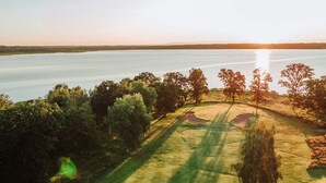 A golf course with a water body in the background. - 4 Person Holiday Home in Arkelstorp (Arkelstorp)