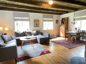 A living room with a sofa, a round coffee table, a dining table with chairs, and a chandelier. - 4 Person Holiday Home in Arkelstorp (Arkelstorp)