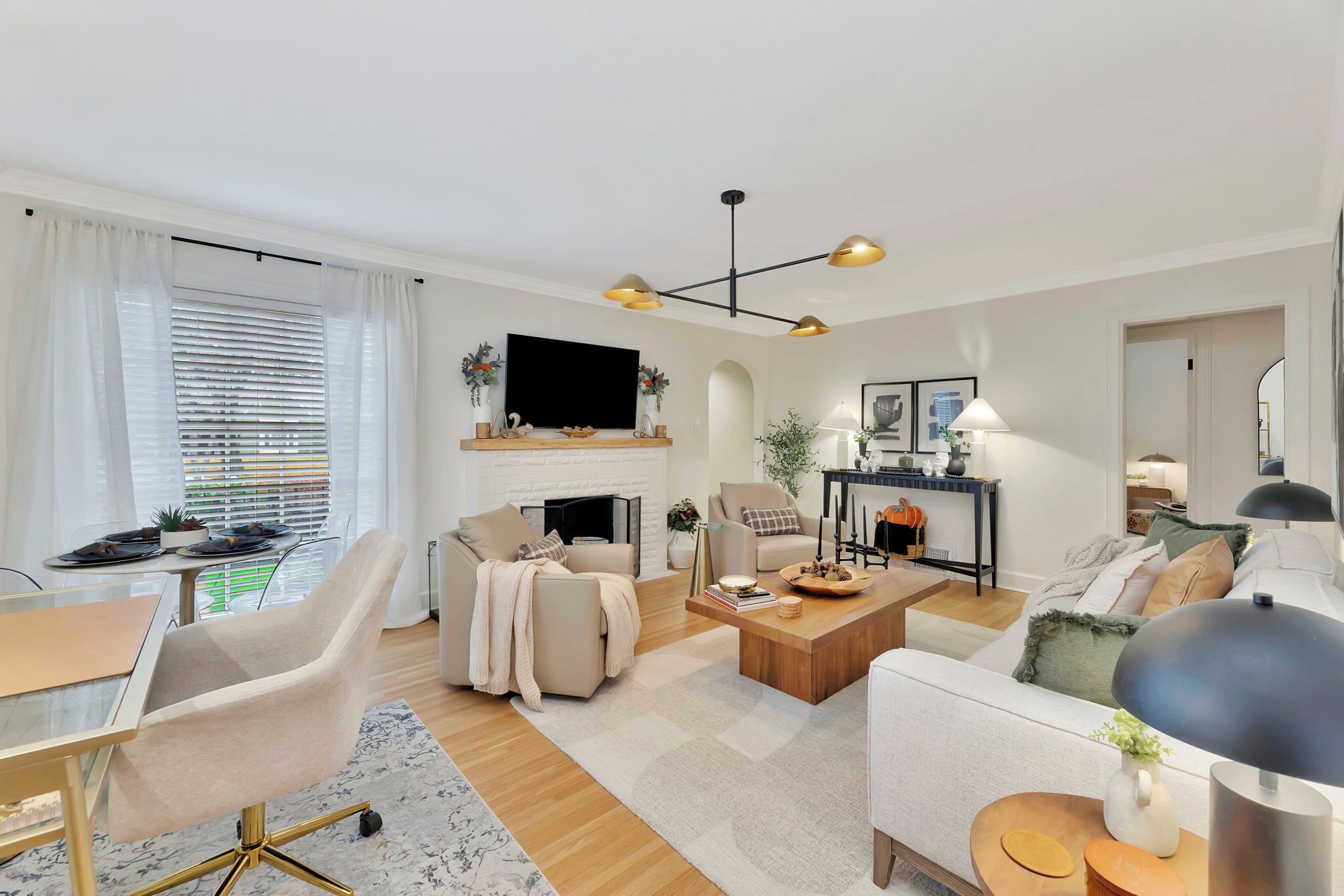Una sala de estar moderna con chimenea, televisor, comedor y una mesa de centro.