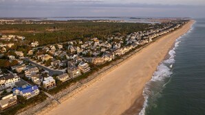 A coastal residential area with houses along the beach, a clear view of the ocean, and a distant shoreline. - Oceanview 5-BR House in Bethany Beach w/ Elevator (Bethany Beach)