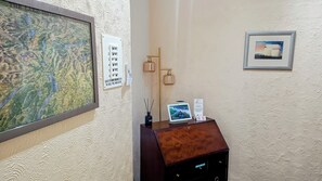 Un mostrador de recepción con un mapa, un botiquín de primeros auxilios, una pantalla digital y una obra de arte enmarcada en la pared.