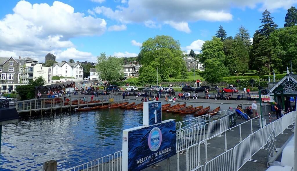 A waterfront area with a pier, boats, and buildings in the background.