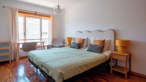 A bedroom with a bed, bedside tables, a chair, and a window with curtains.