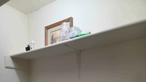A laundry area with two Maytag washers and dryers, a shelf with a framed picture and jars labeled "Laundry Club," and a white wall. - Northgate Home (Bossier City)